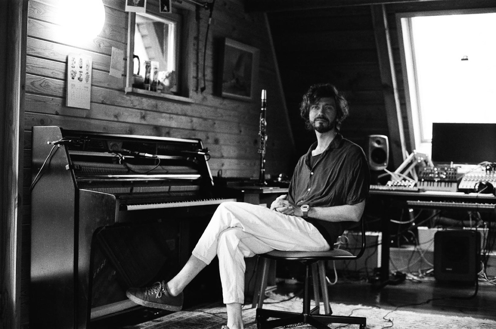 Vova Antoniv in his studio, seated by the piano