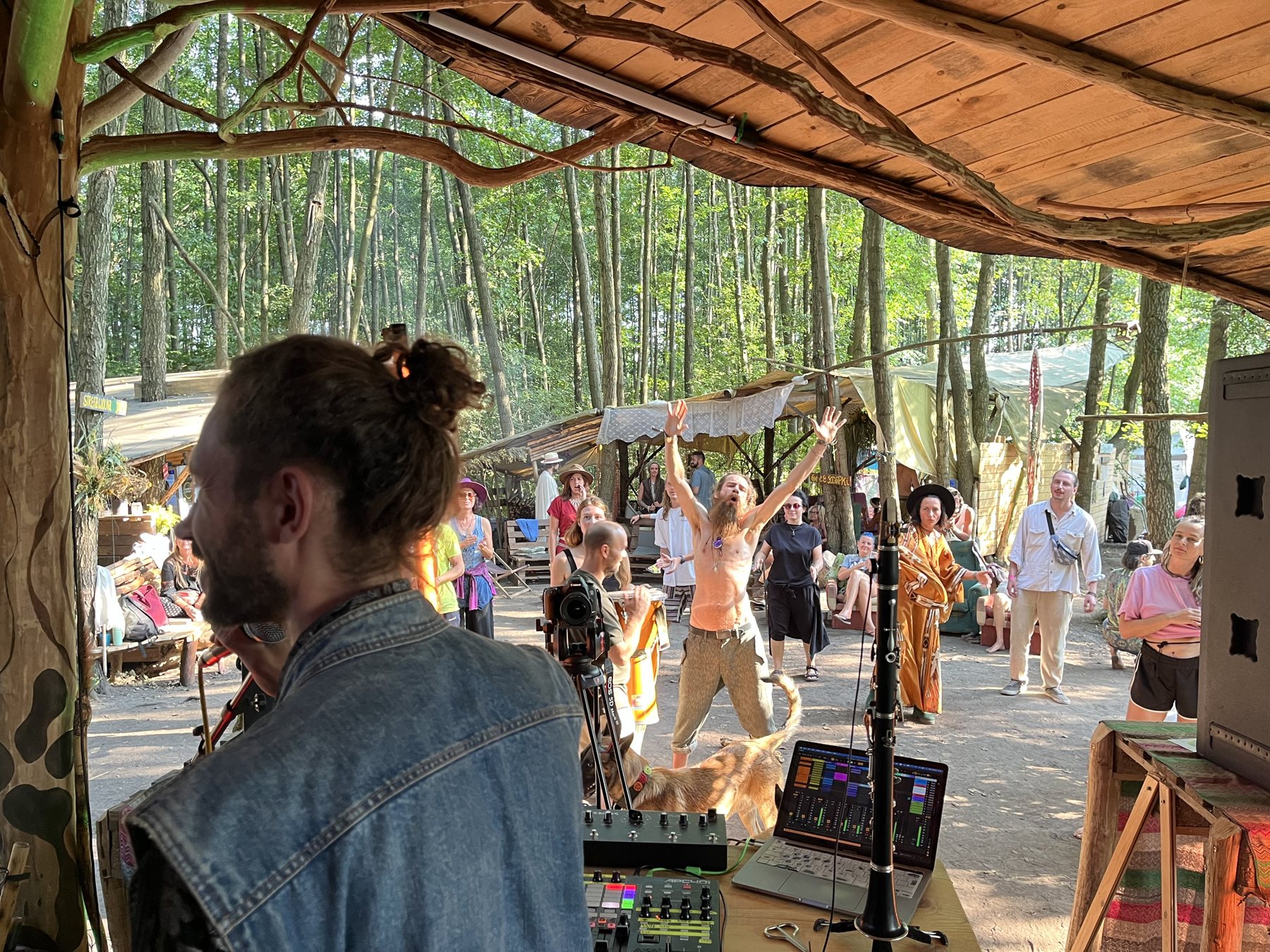 Seen from behind the desk at Bagnowianki 2026, people dancing in daylight under the trees
